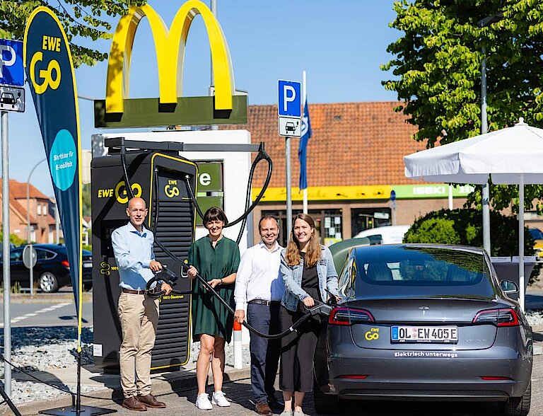 Mitarbeiter von EWE Go und McDonalds posieren mit der 250. EWE Go Ladesäule