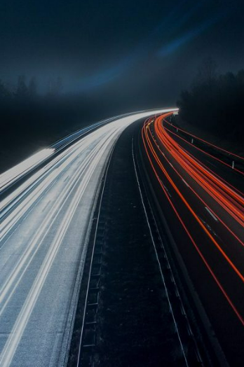 Autobahn bei Nacht von oben fotografiert.