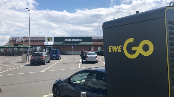 EWE Go Ladesäule auf dem Parkplatz eines McDonalds-Restaurants.