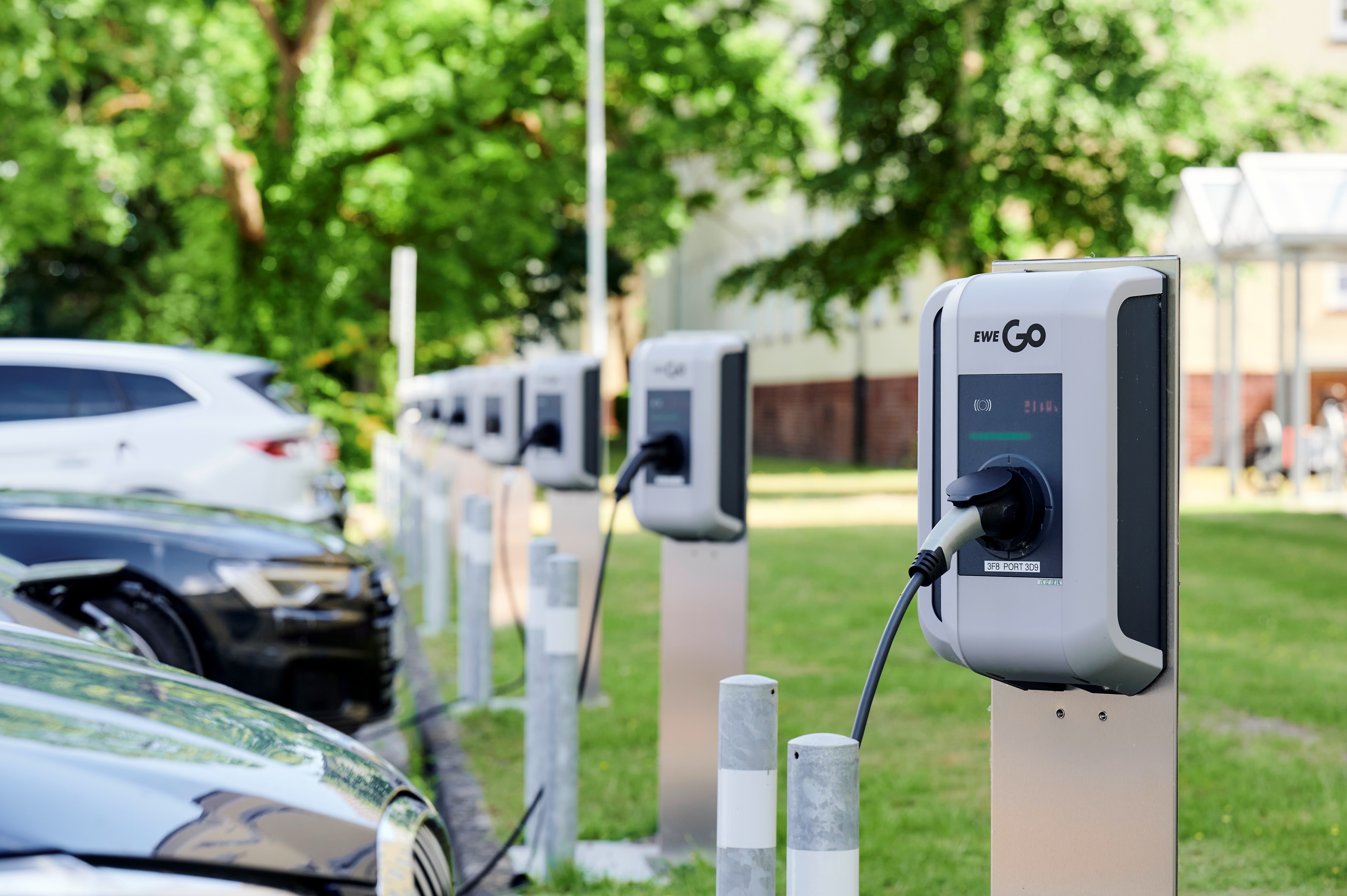Autos werden auf einem Parkplatz mit Hilfe von EWE Wallboxen mit Strom betankt.