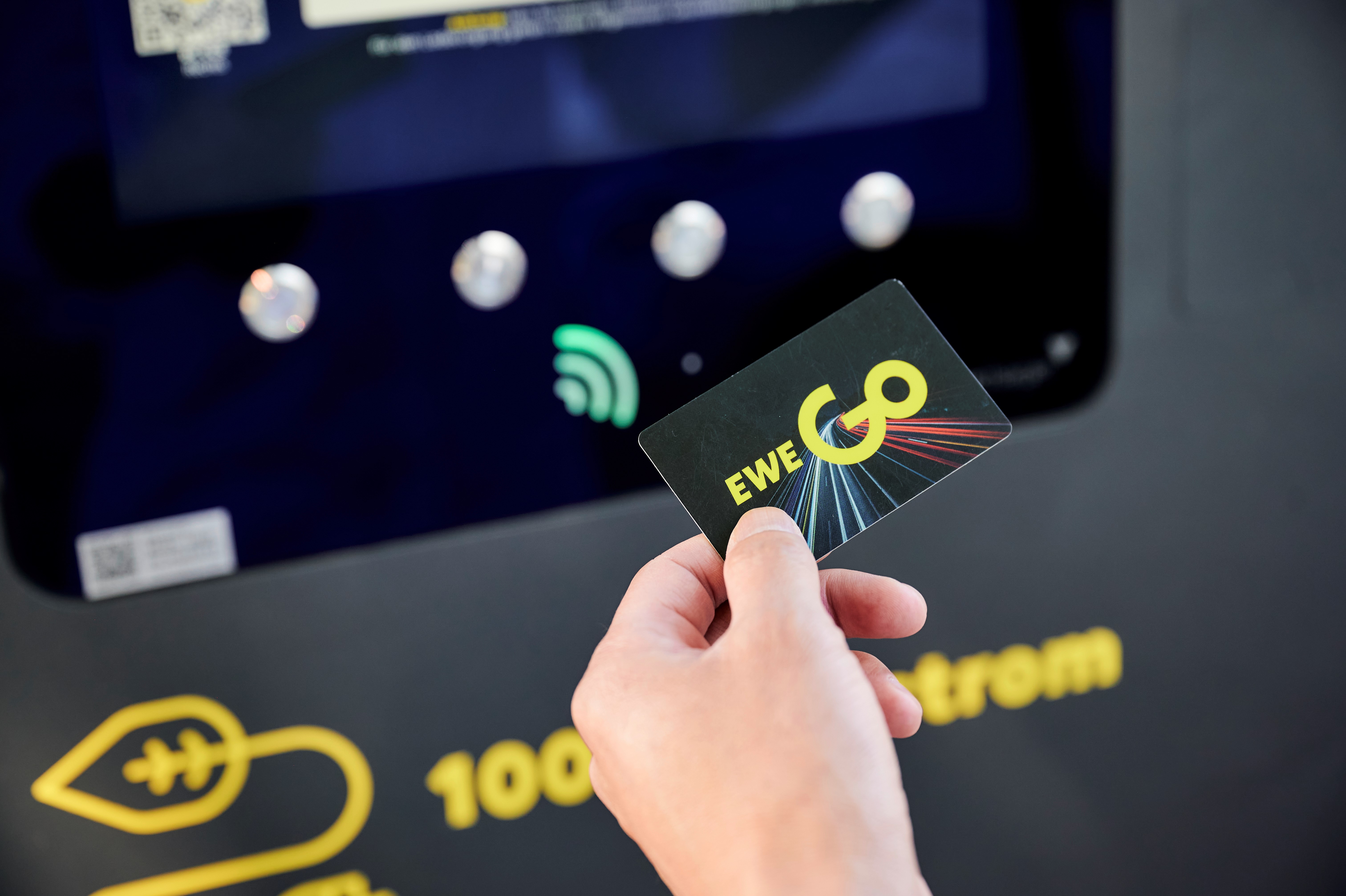 Person hält eine EWE Go Mobility Card in der Hand.
